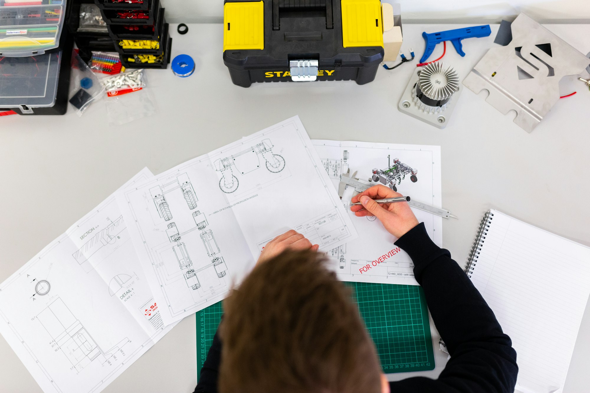Engineer working over technical drawings at a workbench